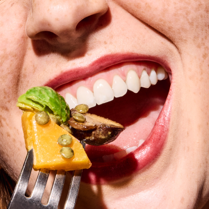 mouth eating vegetables on a fork.