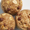 Close-up of homemade oat and nut energy balls on a wooden surface, highlighting their texture and natural ingredients.