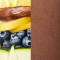 Close-up of a chocolate mousse dessert topped with fresh blueberries and a slice of lemon zest on a white plate