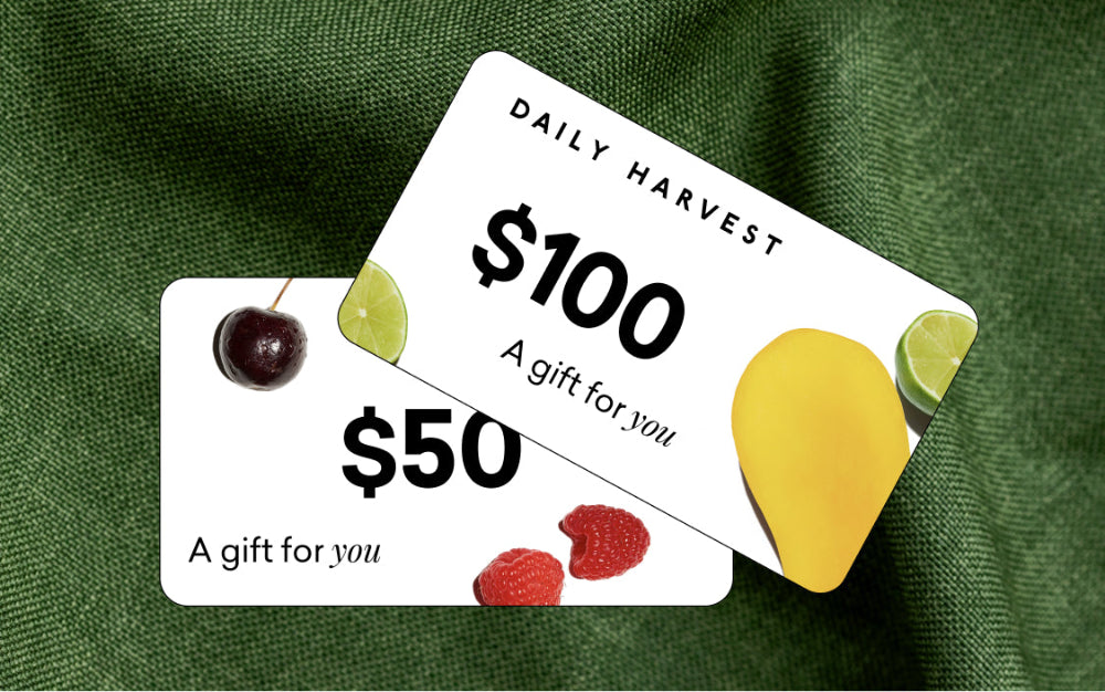 Two gift cards for Daily Harvest on a green fabric background