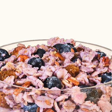 Muesli with berries and nuts in a glass bowl on a white background