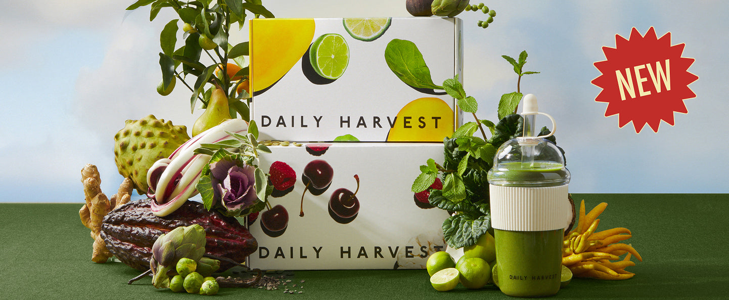 Daily Harvest box with fresh produce and a green bottle on a table. New!