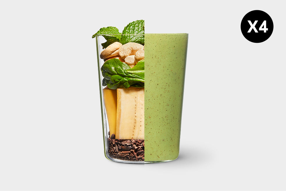 Green smoothie in a glass with ingredients on a white background