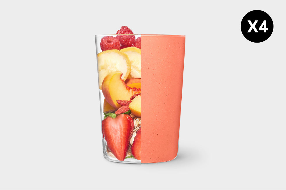 Glass filled with fruit and a coral-colored lid on a light gray background