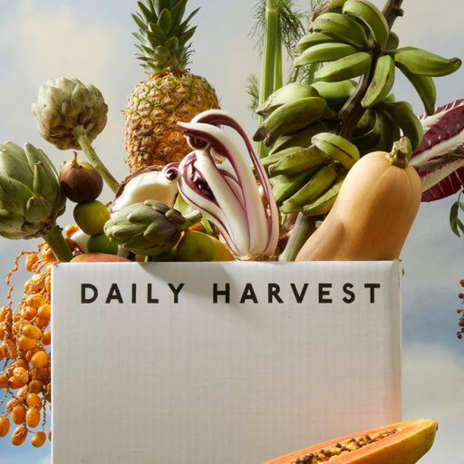 Assorted fruits and vegetables with 'Daily Harvest' branding against a natural background.