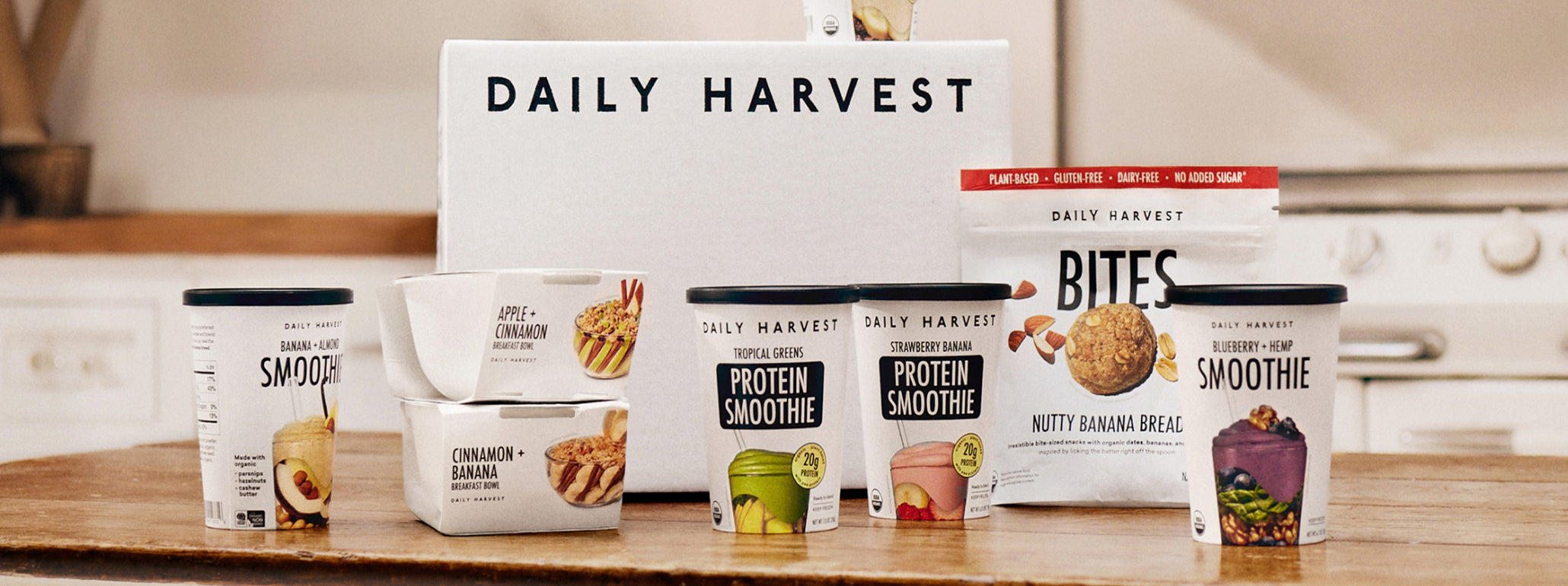 Daily Harvest products including smoothie boxes and protein bites on a kitchen counter.