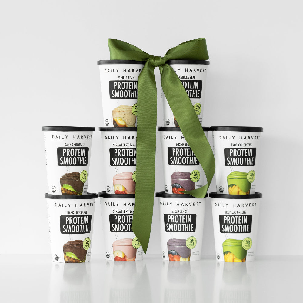 Stacked Daily Harvest high protein smoothie cups with green bow and sale sign on white background