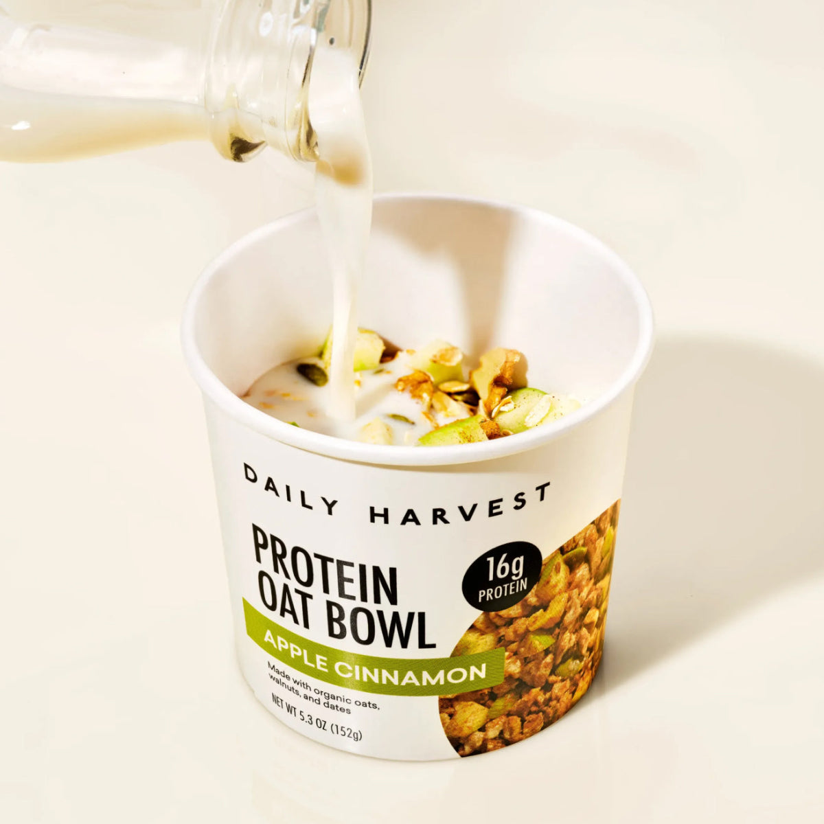 Daily Harvest protein oat bowl with milk getting poured in.